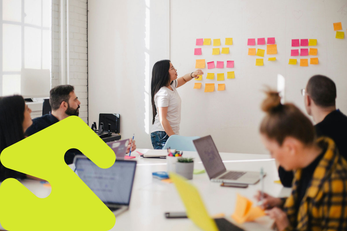 Fem personer som samarbeider og bruker post-it lapper