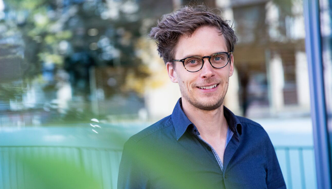 Portrett a smilende ung mann med briller